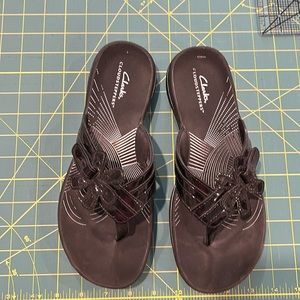 Lightly worn Clarks flip-flop with patent leather detail